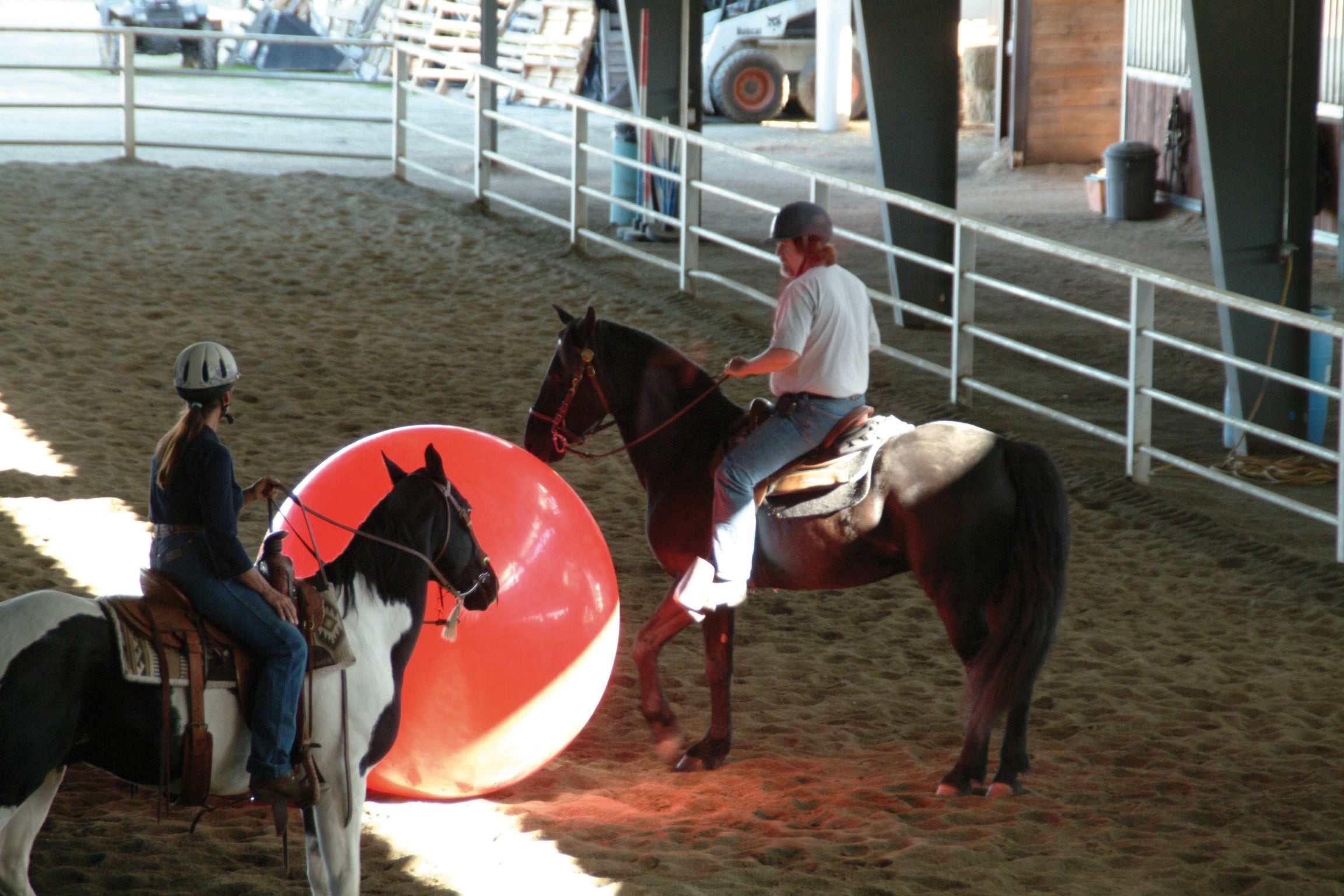 Horse riders training with a red megaball