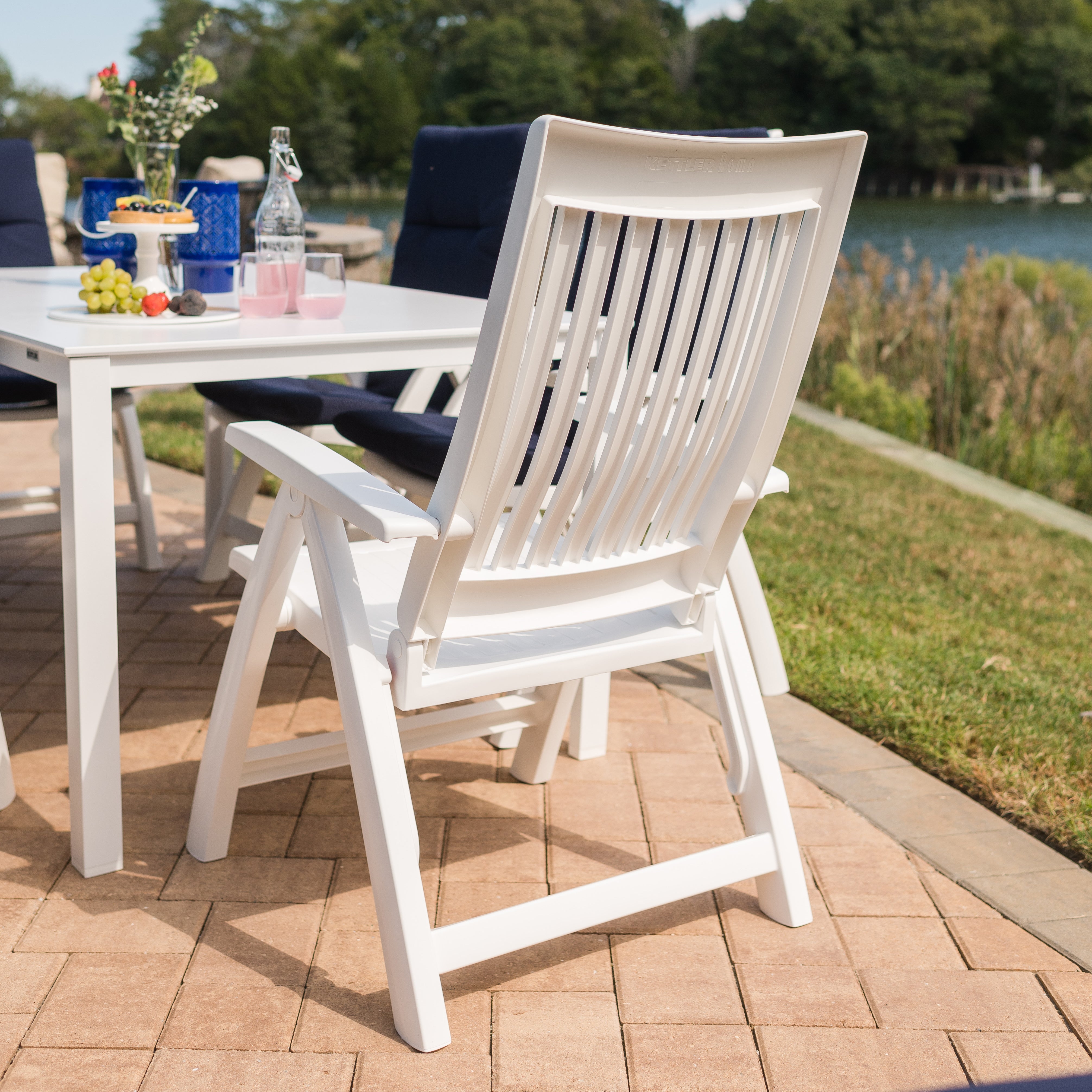 Roma 3-Piece Lounge Set with Cushions featuring white resin multi-position chair and side table outdoors.