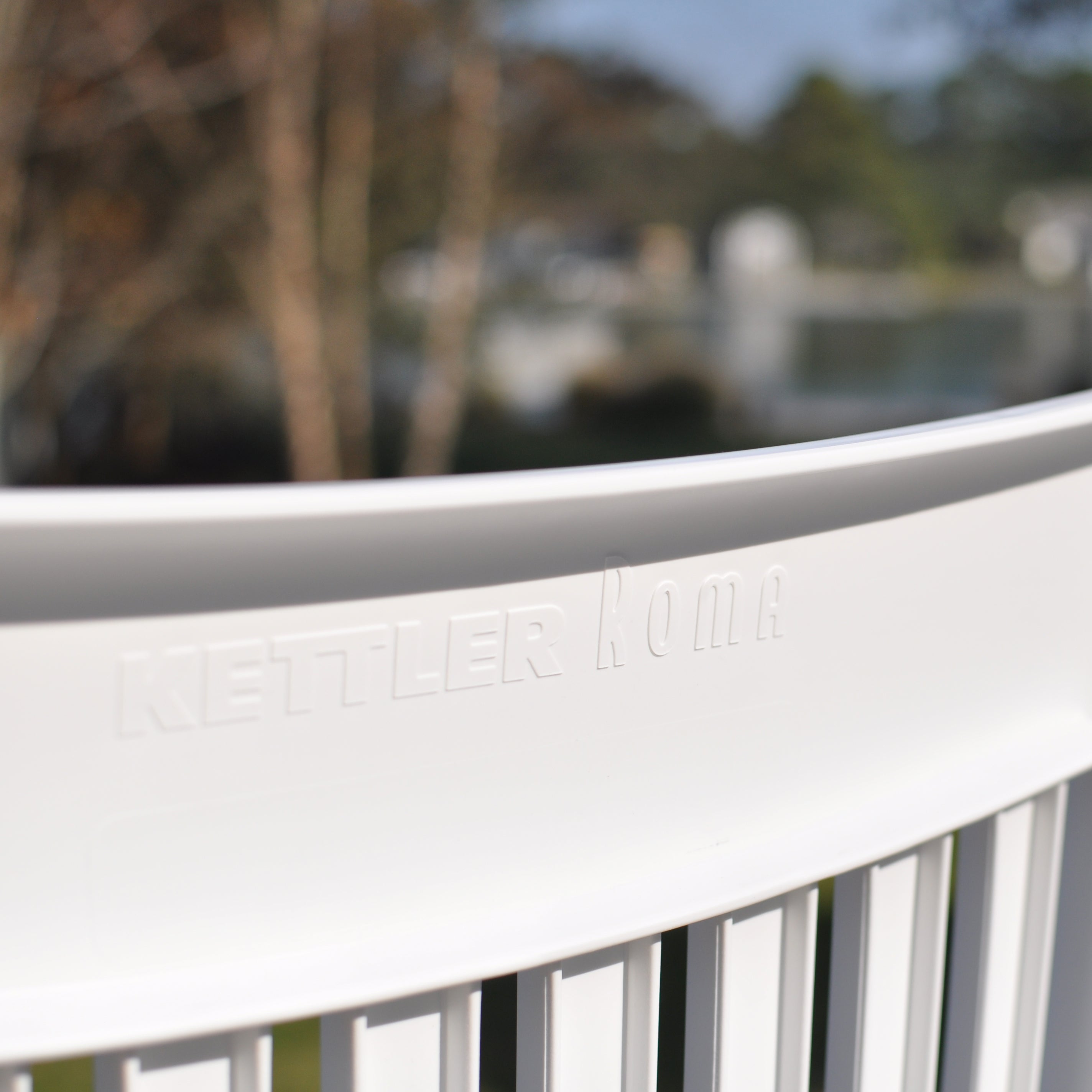 Close-up of white resin chair back with embossed Kettler Roma on the Roma 3-Piece Lounge Set with Cushions.