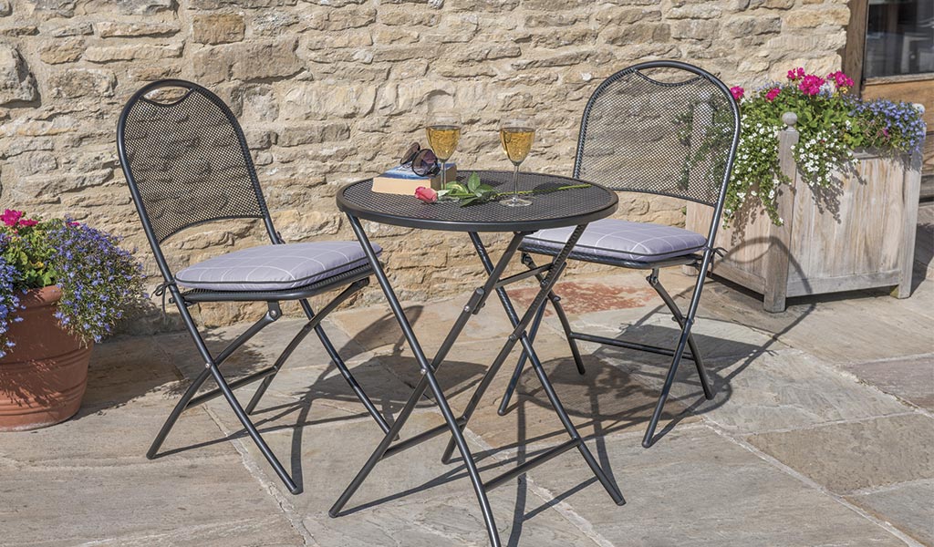 Lifestyle image of three piece wrought iron bistro set 