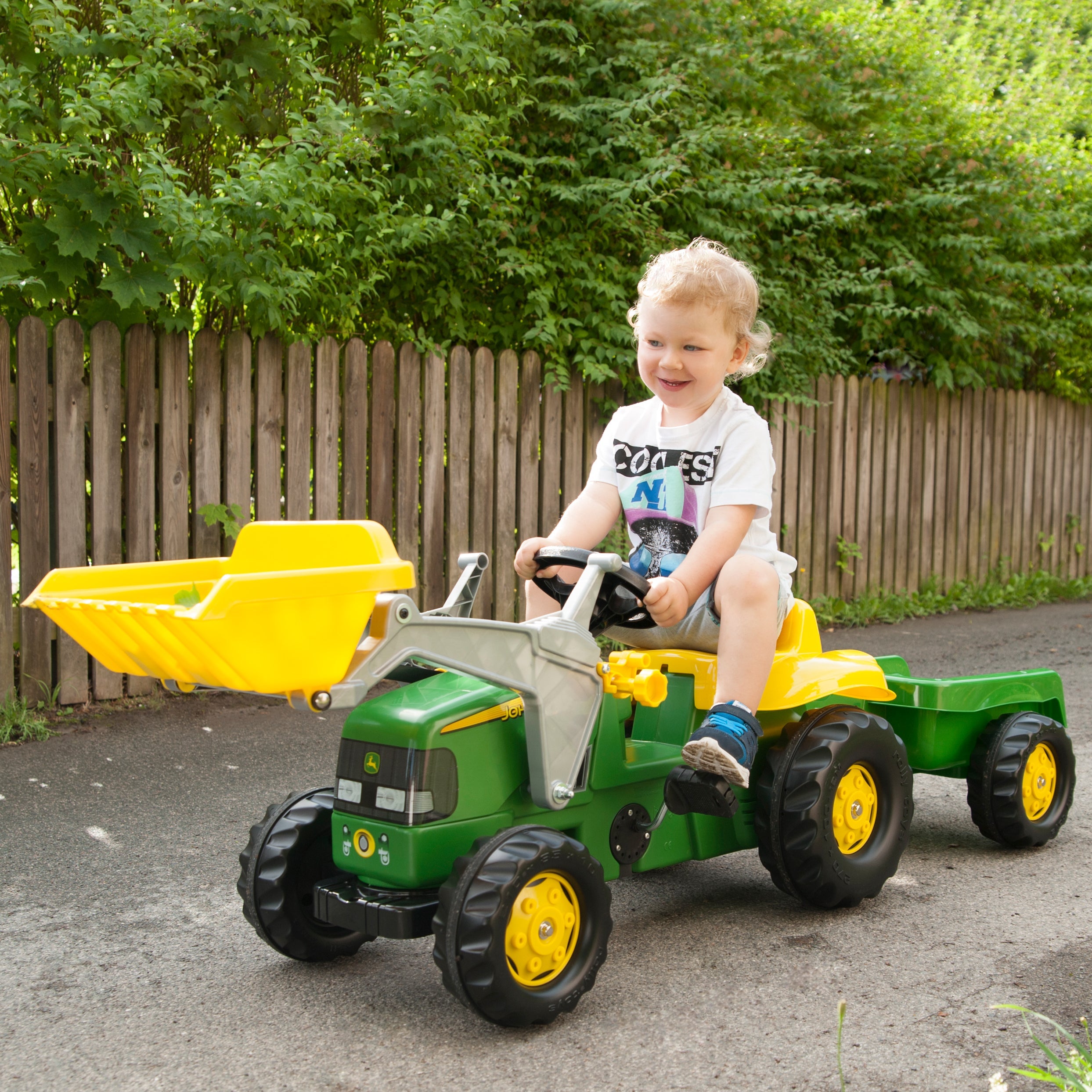 lifestyle image of child riding JD ride on vehicle with functional front loader 