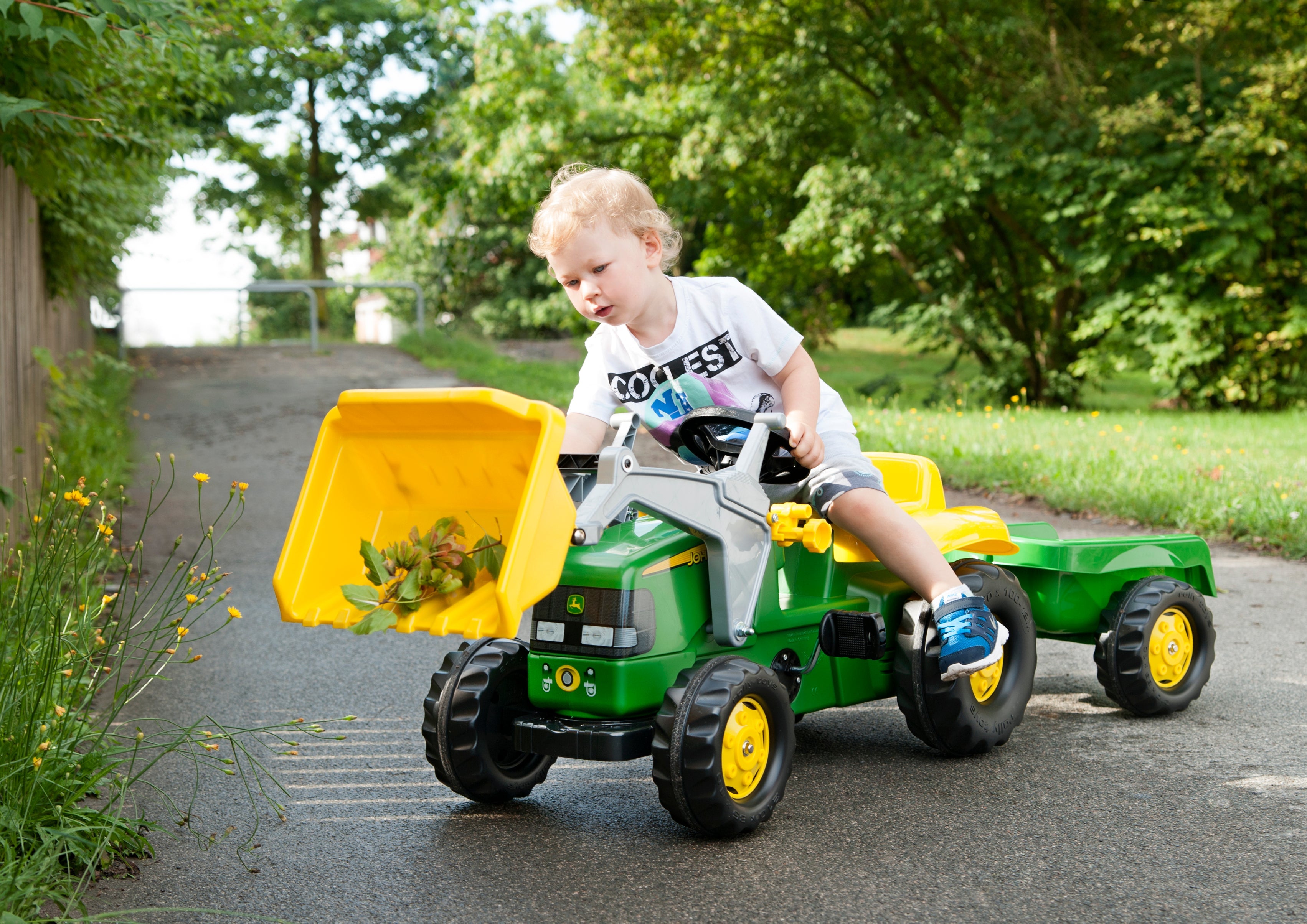 Child dumping load from front loader on high quality blow molded john deere ride on resin tractor